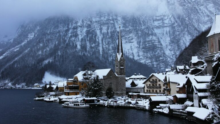 village near body of water and moutain